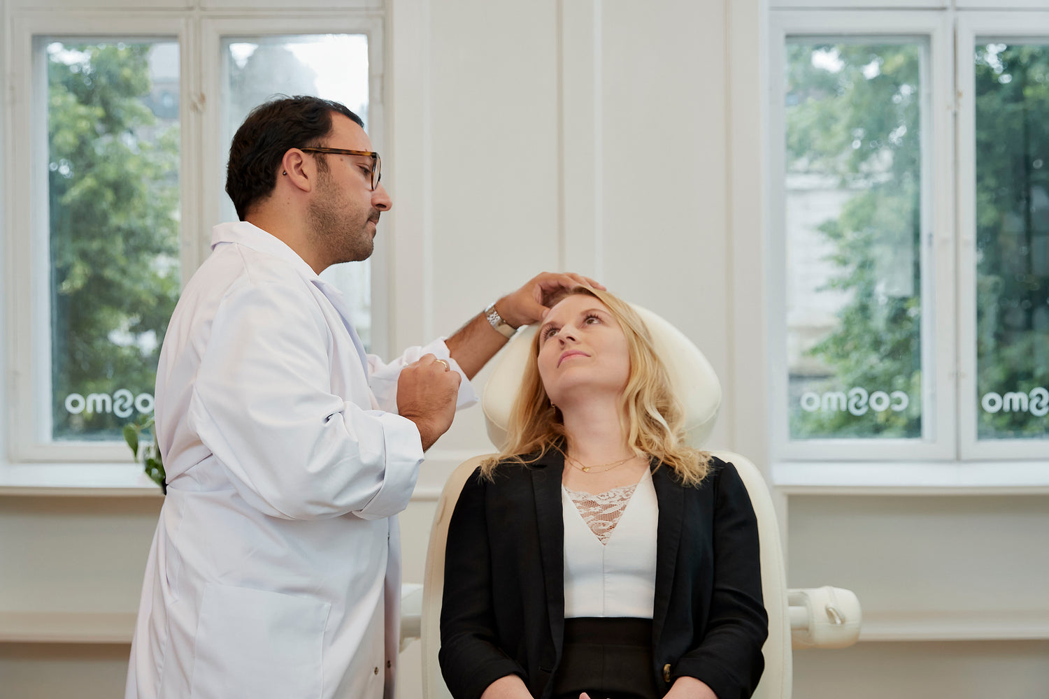 Kosmetisk læge hos Cosmo Laser København konsulterer kvindelig patient før laserbehandling.