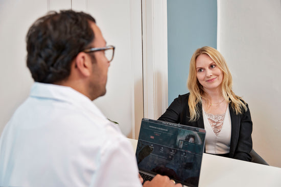 Kvinde i konsultation med læge hos Cosmo Laser om botox behandling.