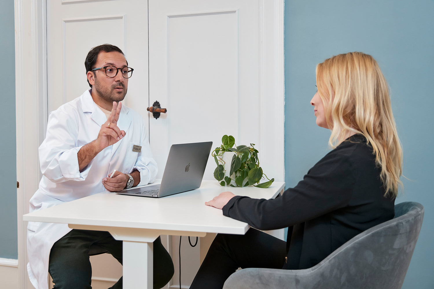 Kosmetisk læge hos Cosmo Laser København forklarer laserbehandling til patient.