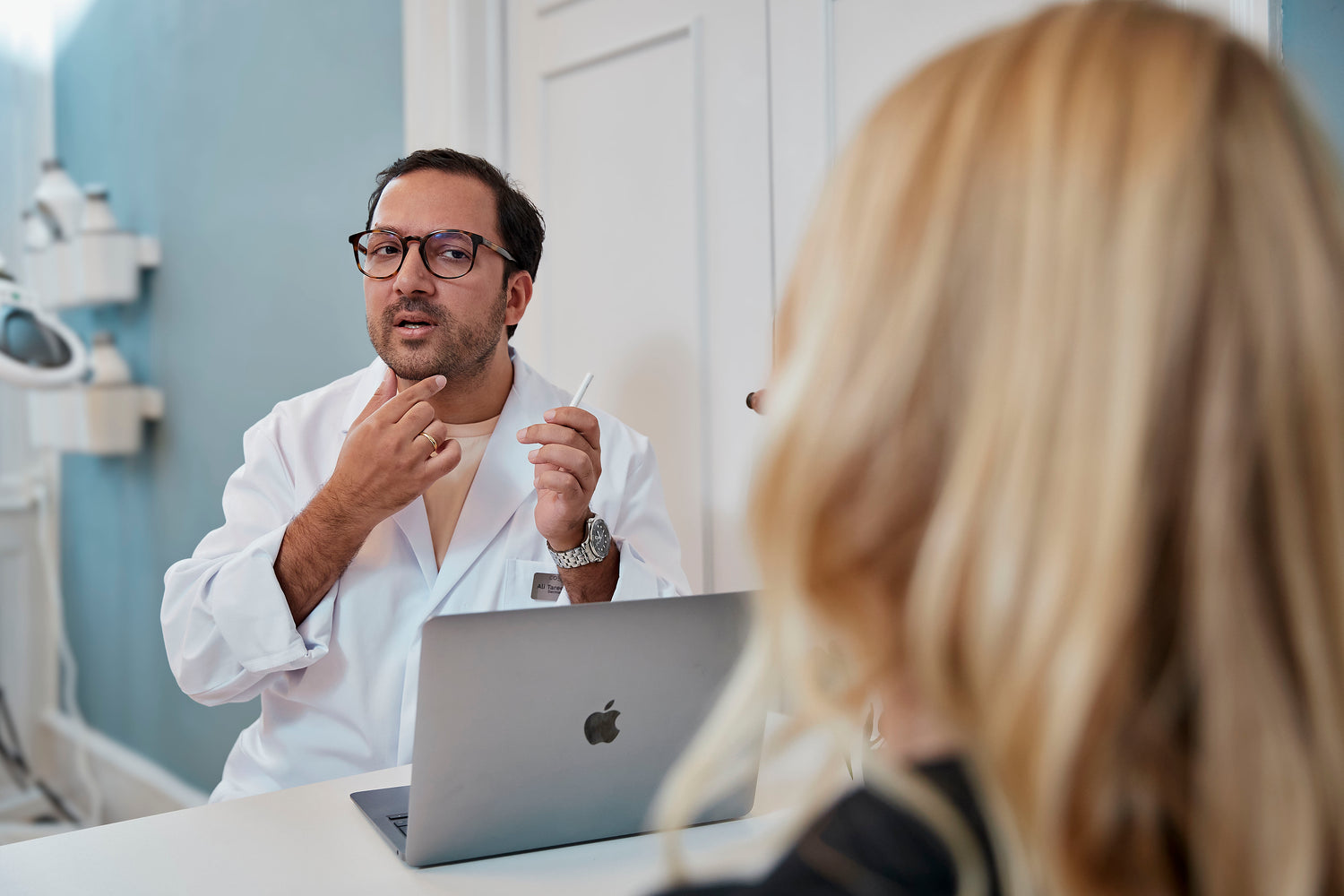 Kosmetisk læge hos Cosmo Laser København forklarer botox behandling til patient.