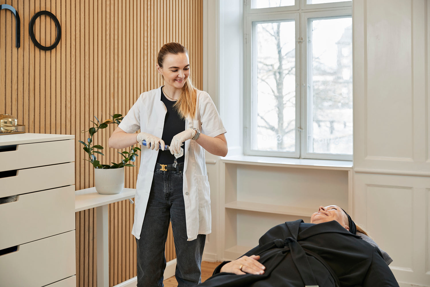 Kosmetisk laserbehandling hos Cosmo Laser: Behandler klargør udstyr til behandling af klient.