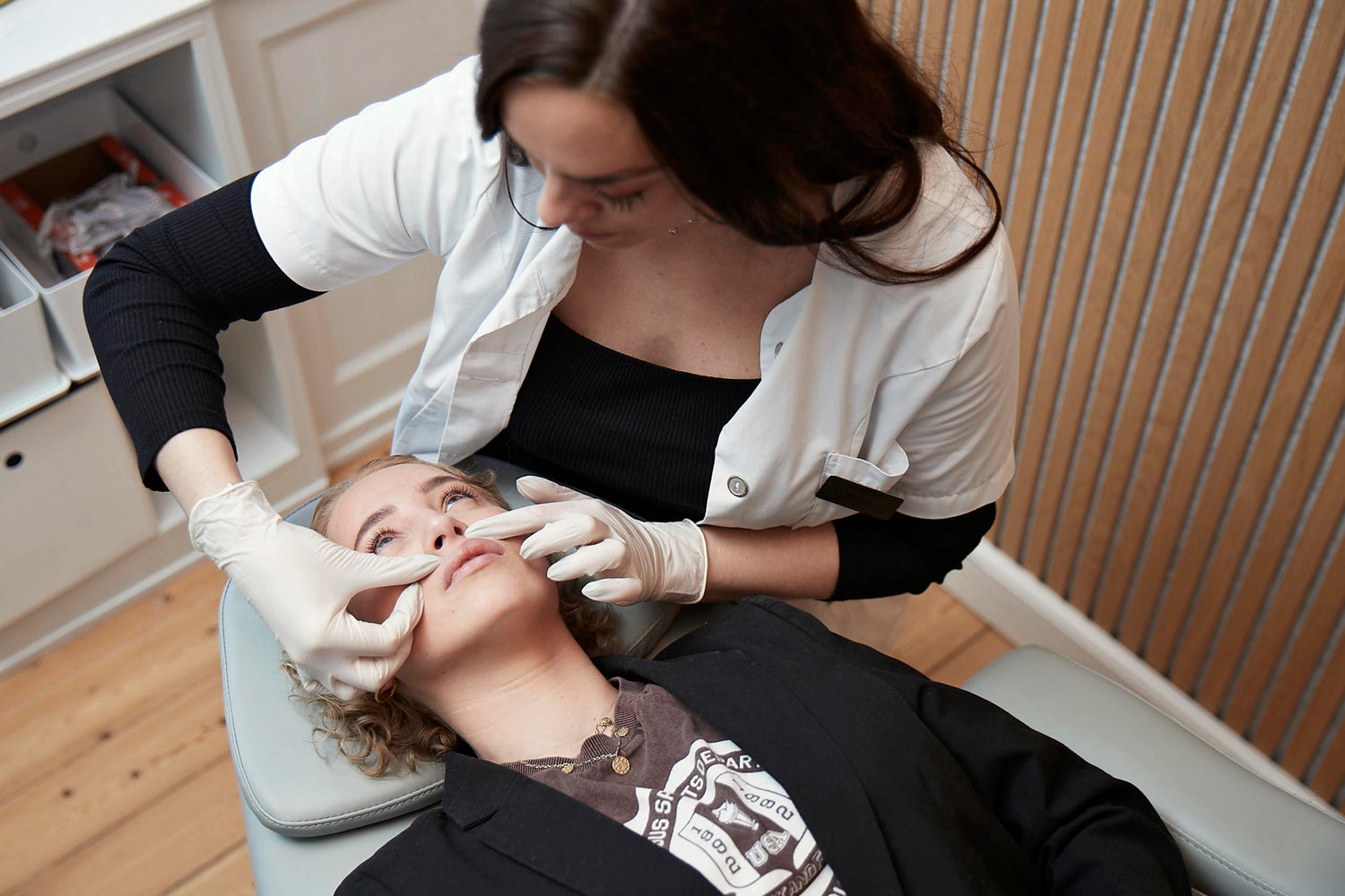 Kosmetisk laserbehandling hos Cosmo Laser: Behandler undersøger klient før laserprocedure.