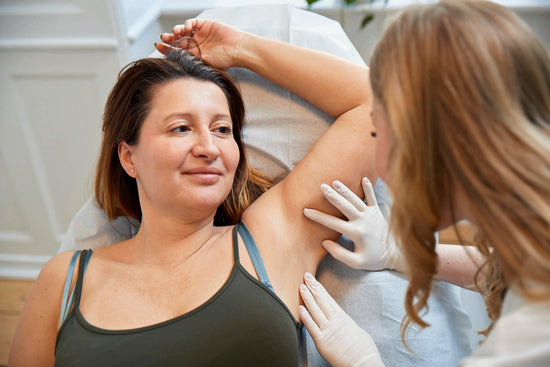 Kosmetisk laserbehandling hos Cosmo Laser: Behandler undersøger patientens arm før behandling.