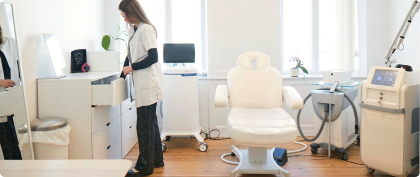 Kosmetisk klinik hos Cosmo Laser København. En behandler forbereder laserbehandling i et lyst behandlingsrum.