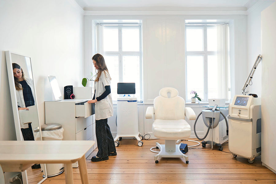 Behandlingsrum hos Cosmo Laser med briks, spejl og laserudstyr