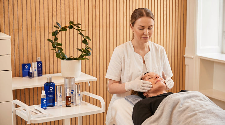 Behandler i gang med en ansigtsbehandling i klinikken