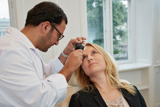 Kosmetisk læge hos Cosmo Laser undersøger klient med dermatoskop før laserbehandling.