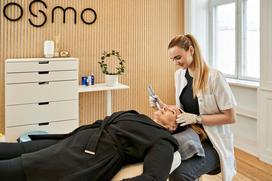 Kosmetisk laserbehandling hos Cosmo Laser. En behandler udfører en laserprocedure på en klient.